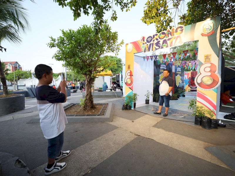 Warga berfoto di reflika Lorong Wisata. 