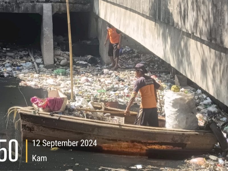 Satgas Kanal Dinas PU Makassar melakukan pembersihan tumpukan sampah di Kanal Jongaya mengunakan perahu. (Foto: IST)