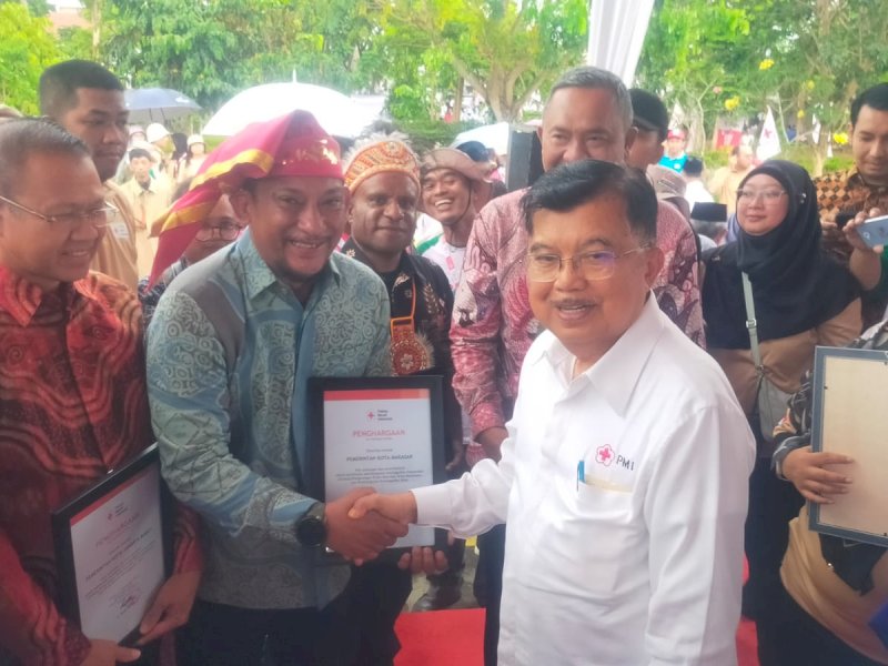 Ketua Umum PMI Pusat, Jusuf Kalla saat memberikan penghargaan kepada Kepala Damkarmat Makassar, Hasanuddin sebagai perwakilan Pemkot.