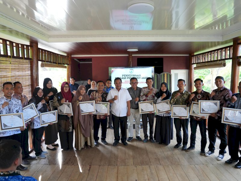 Pj Gubernur Bahtiar Baharuddin, menyerahkan penghargaan kepada guru dan sejumlah tokoh. 