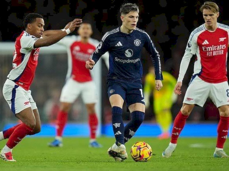 Pemain Arsenal mengadang laju pemain MU. (int) 