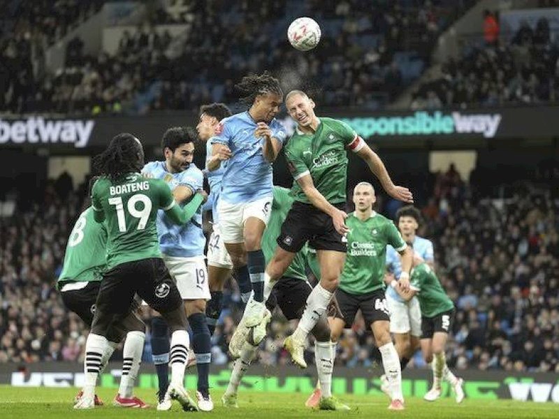 Pemain Manchester City dan Plymouth berebut bola di udara. (int) 