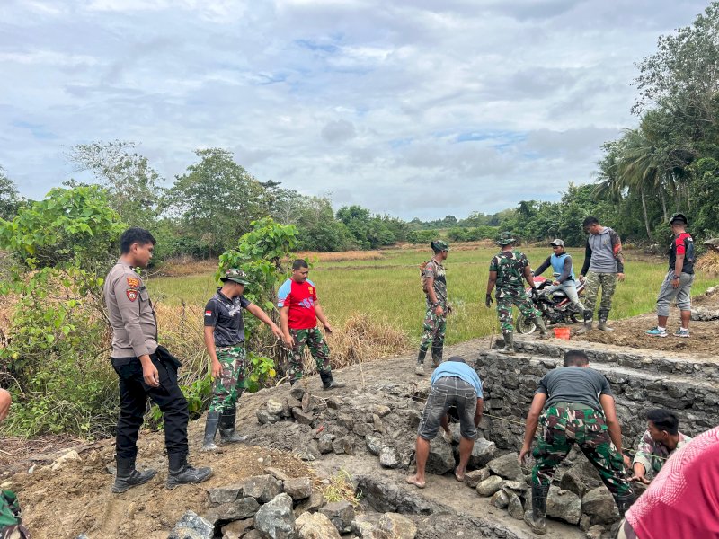 TNI dan Polri bergotong royong membangun jembatan.