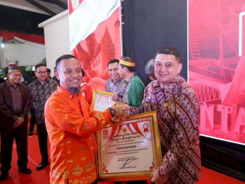 Gubernur Sulsel Sudirman Sulaiman menyerahkan penghargaan kepada Wali Kota Makassar Munafri ''Appi' Arifuddin.