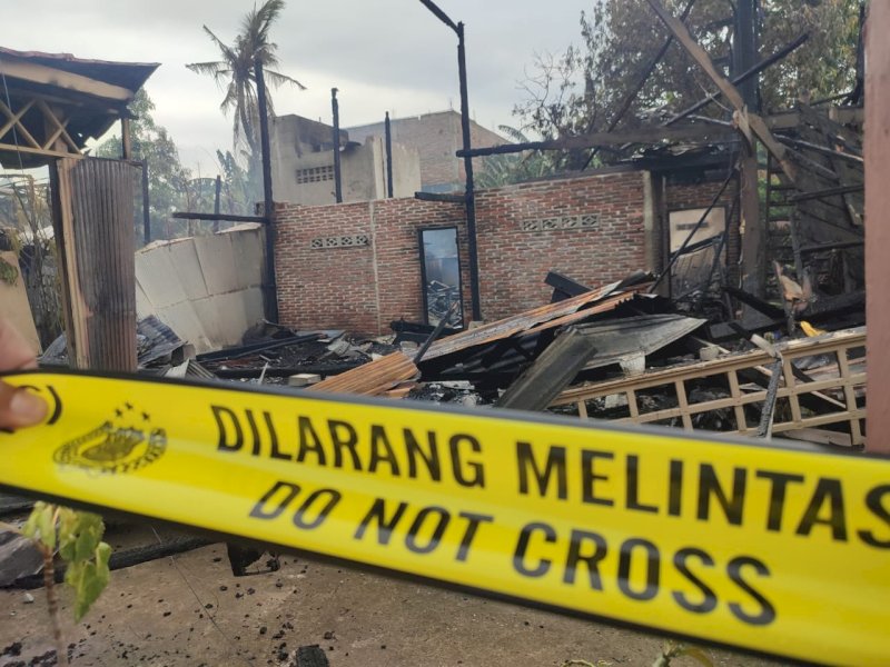 Polisi memasang police line di lokasi kebakaran. 