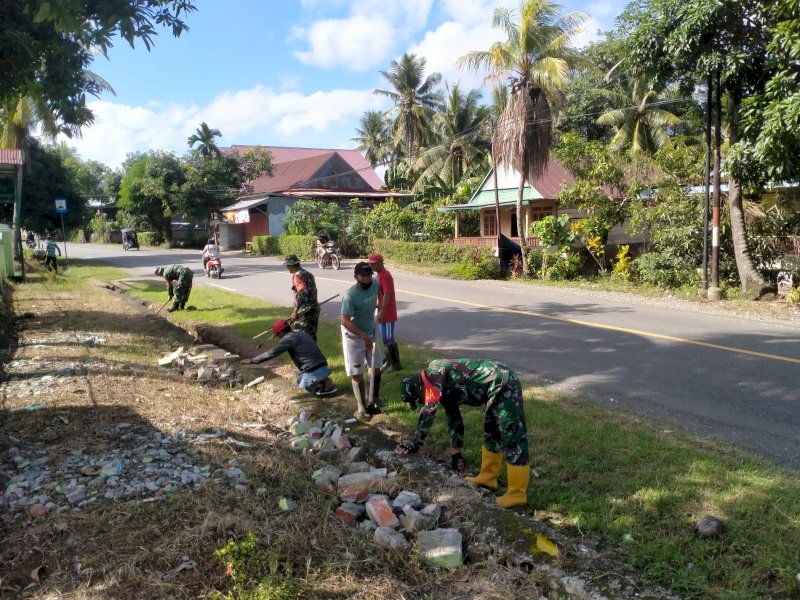 Anggota Koramil 1406-05/Majauleng mengeruk saluran air di wilayah Kelurahan Limpomajang. 