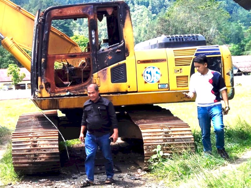 Andung Tiku Gorri bersama salah seorang penyidik kepolisian saat meninjau kondisi bangkai ekskavator. 