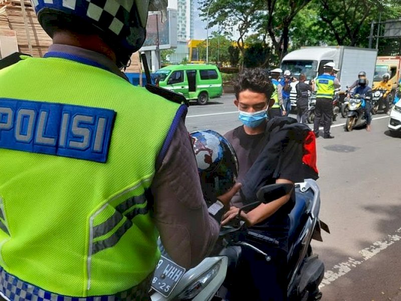 Seorang pengendara yang didapati berkendara tidak menggunakan helm. 