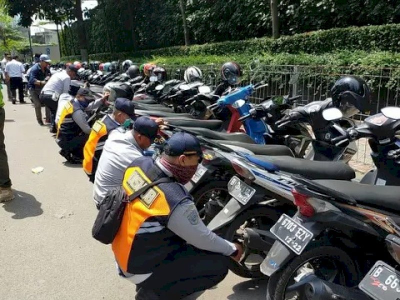 Petugas saat menyegel kendaraan yang parkir sembarangan.