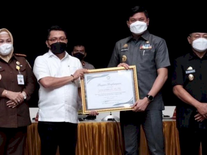 Bupati Gowa Adnan Purichta Ichsan memberikan piagam penghargaan kepada Kepala Kejari Gowa Andriani atas penyelamatan aset lahan senilai Rp12  miliar. (Ist)