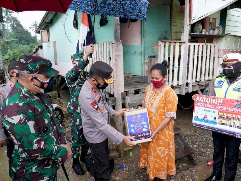 Korem 143 Haluoleo bersama Polda Sultra saat membagikan paket sembako ke warga.