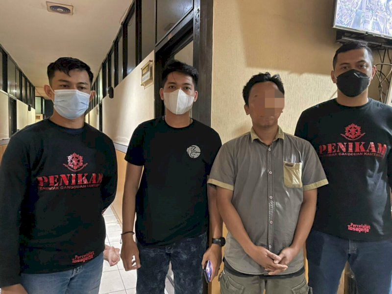 Tersangka diapit petugas usai diringkus.  