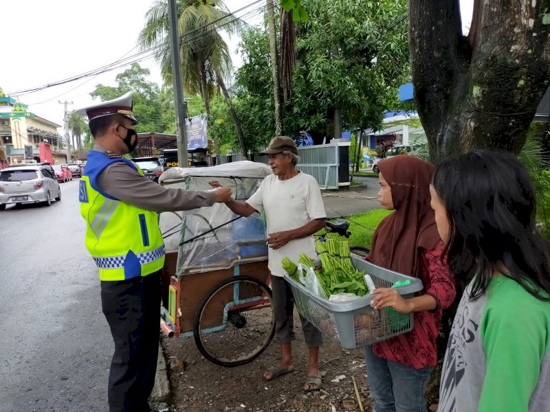 Personel Satlantas Polres Takalar bagikan masker pada pengguna jalan. (Ist)
