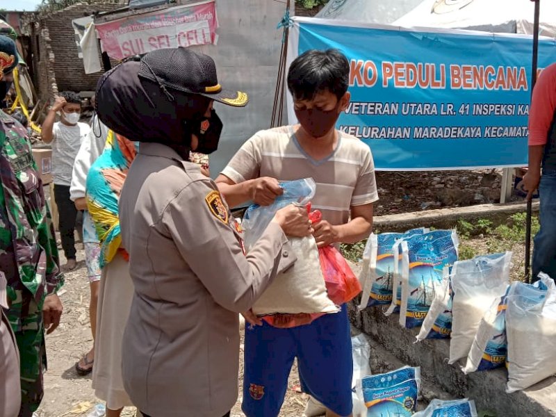 Kapolsek Makassar saat memberikan bantuan untuk korban kebakaran di Veteran Utara.