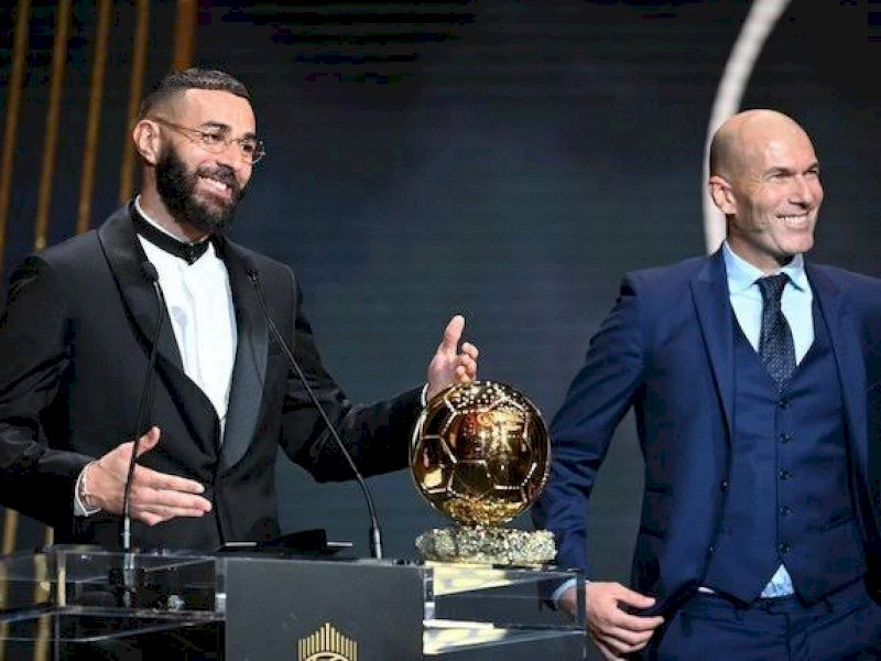 Karim Benzema menerima bola emas dari Zinedine Zidane.