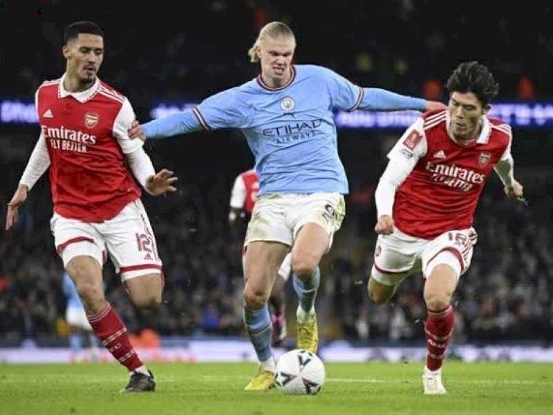 Erling Haaland diapit dua pemain Arsenal. (int)