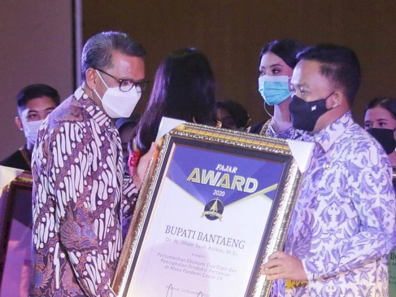 Gubernur Sulsel Nurdin Abdullah saat menyerahkan penghargaan ke Bupati Bantaeng Ilham Azikin. 