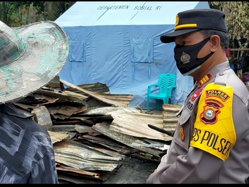 Kapolsek Sanggalangi AKP Ketut Aliasa saat menyerahkan bantuan ke korban kebakaran di Angin-angin. 