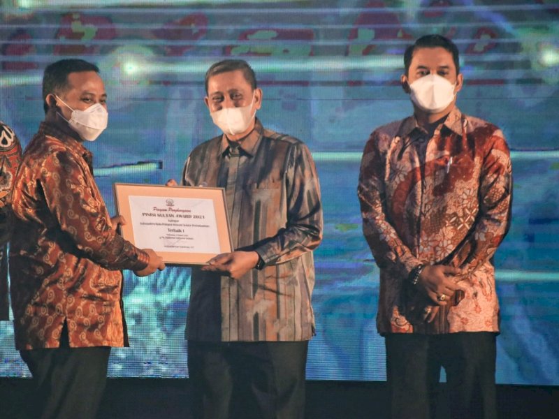 Plt Gubernur Sulsel Andi Sudirman Sulaiman saat menyerahkan penghargaan ke Bupati Wajo. 