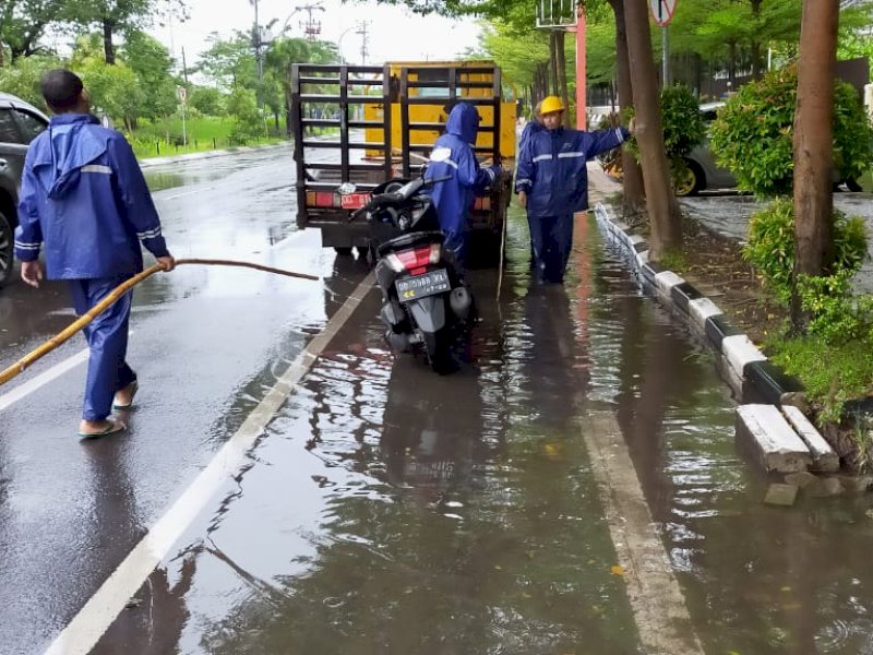 Satgas Dinas PU saat menangani genangan banjir di Makassar. 