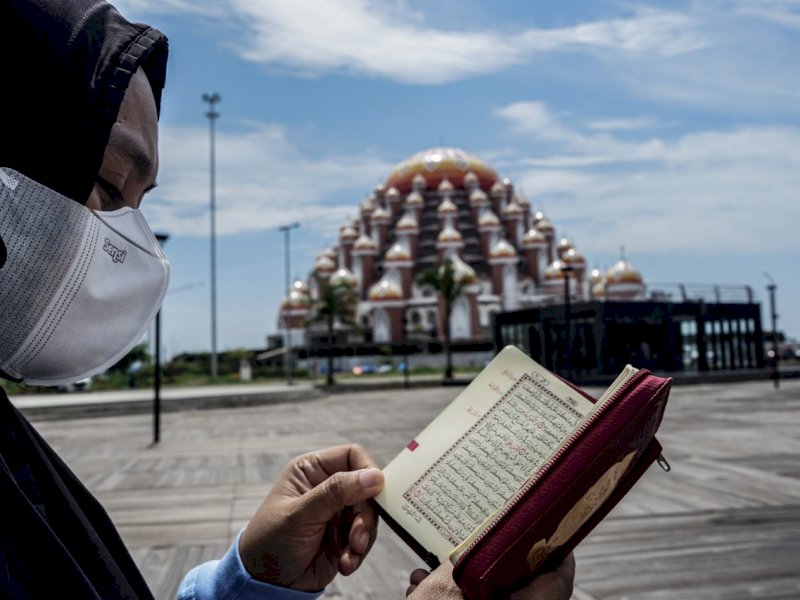 Foto seorang wanita yang mengaji Masjid Kubah 99 Makassar. 