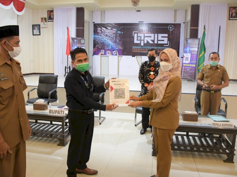 Bupati Lutra saat meluncurkan penggunaan QRIS untuk transaksi pembayaran PAD. 