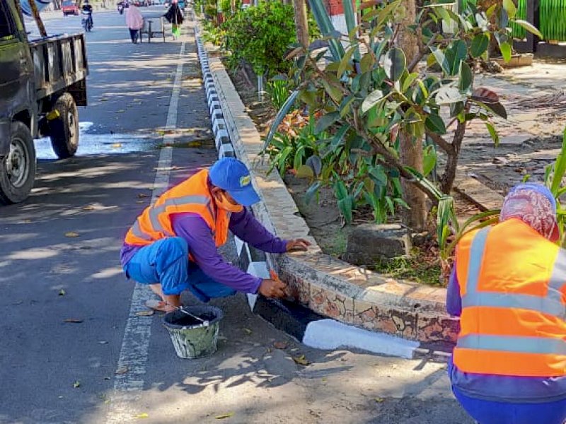 Satgas Dinas PU Makassar saat mengecat trotoar jalan. 
