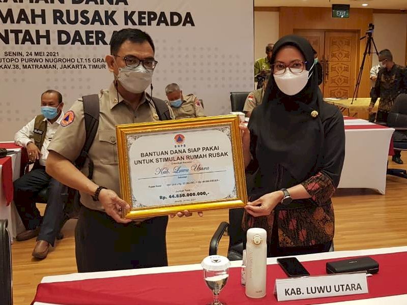 Bupati Lutra saat menerima secara simbolis bantuan Huntap. 