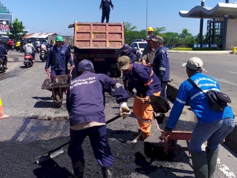 Satgas Pemeliharaan Jalan Dinas PU Makassar saat melakukan penambalan jalan. 