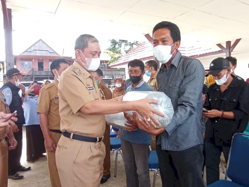 Bupati Wajo Amran Mahmud menyerahkan bibit ikan untk ditebar di kawasan integritas farming. 