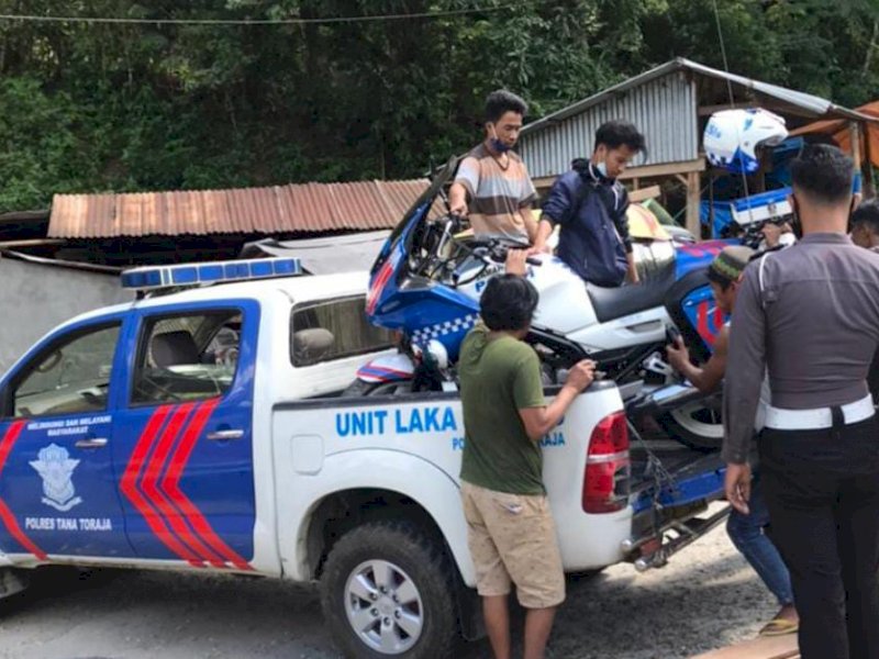 Petugas mengevakuasi motor patwal yang ditabrak. 
