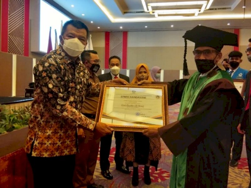 Andi Utta saat menerima penghargaan dari Stimik Handayani. 