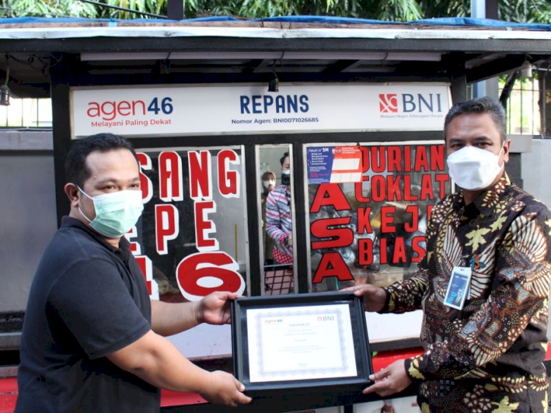 Pemimpin BNI wil 07 Hadi Santoso menyerahkan sertifikat BNI Agen46 kepada pedagang pisang epe.