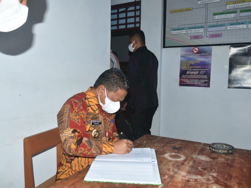 Bupati Torut Yohanis Bassang mengecek absen pegawai di Kecamatan Balusu. 