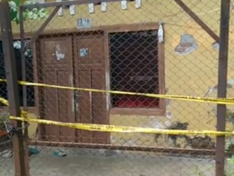 Polisi memasang police line di rumah korban. 