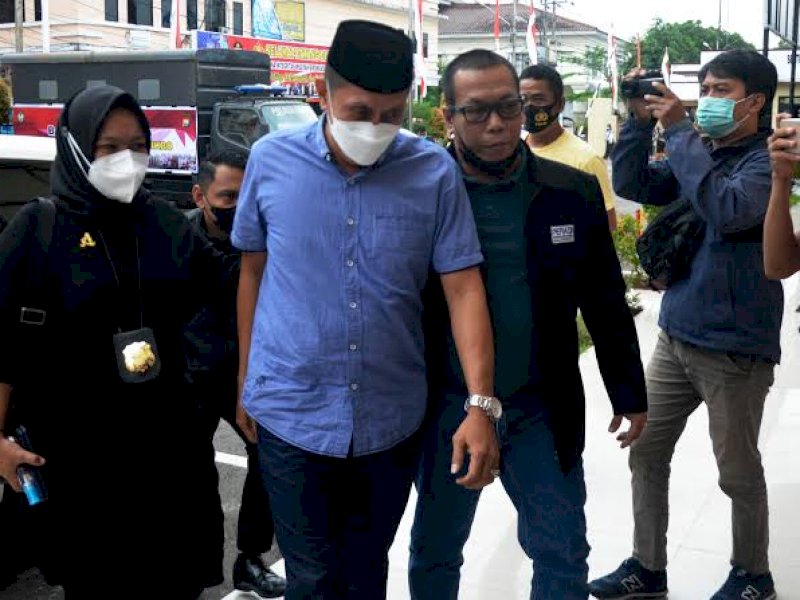 Eks Sekretaris Satpol PP Gowa Mardani Hamdan (pakai peci) saat tiba di Polres Gowa beberapa waktu lalu. (Ist)