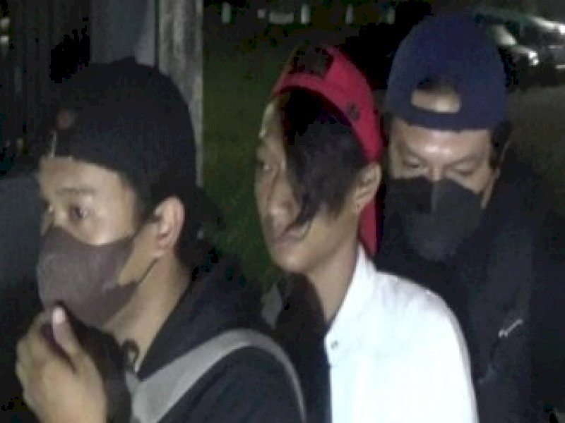 Randi diapit petugas saat diamankan dini hari tadi.