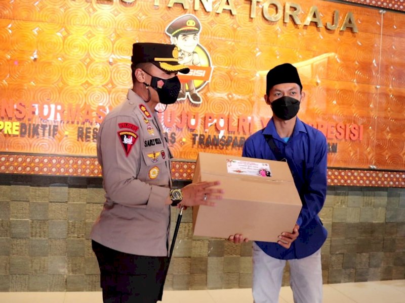 Kapolres Tator AKBP Sarly Sollu menyerahkan bingkisan Nataru kepada wartawan.