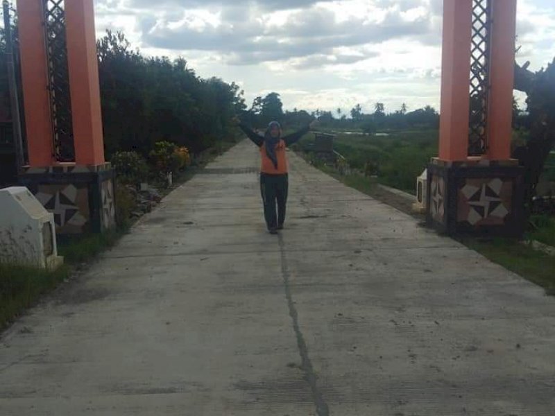 Seorang warga desa menikmati jalan beton di Wajo. (Foto: Ist)