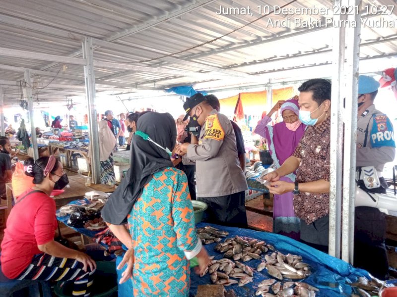 Camat Tempe Kabupaten Wajo Supardi memeriksa kartu vaksin di pasar. (Foto: Ist)