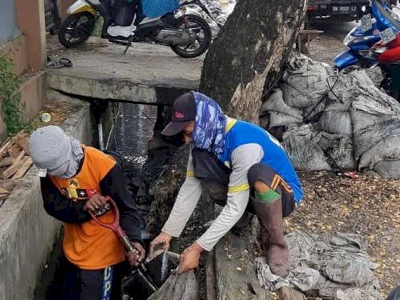 Tim Satgas Drainase DPU Makassar melakukan pengerukan drainase.