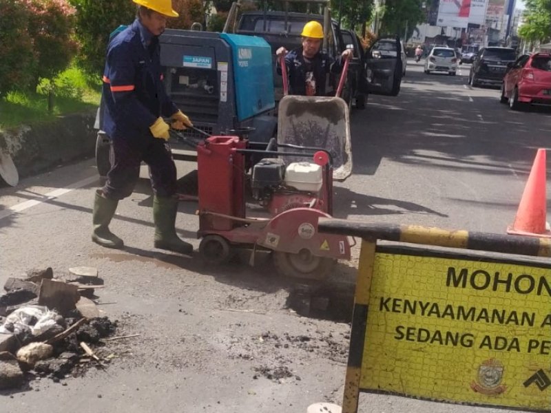 Dinas PU Makassar melakukan pembenahan jalan ambruk di Jalan Penghibur. 