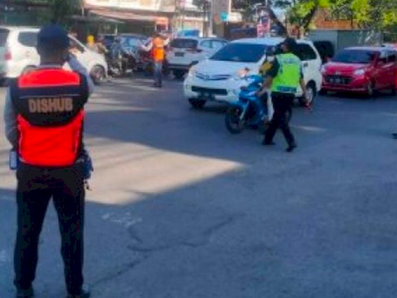 Pegawai Dishub Makassar melakukan pengaturan lalu lintas. 