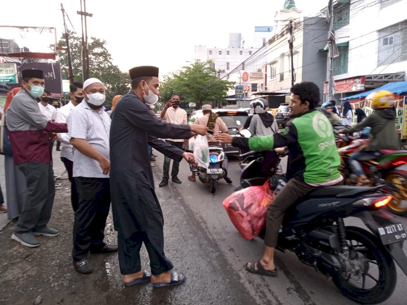 Ketua Umum Ikatan Alumni SMA 6 Makassar, Rudianto Lallo membagikan takjil pada pengguna jalan. 