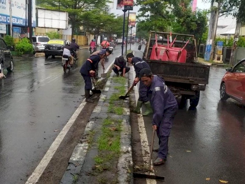 Satgas Pemeliharaan Jalan Bidang Jalan dan Jembatan Dinas Pekerjaan Umum (PU) Kota Makassar  merapikan median jalan. 