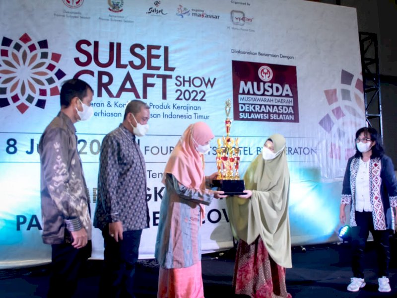 Ketua Dekranasda Wajo, Sitti Maryam menerima penghargaan yang diserahkan Ketua Dekranasda Sulsel Naoemi Octarina, Rabu (8/6/2022).