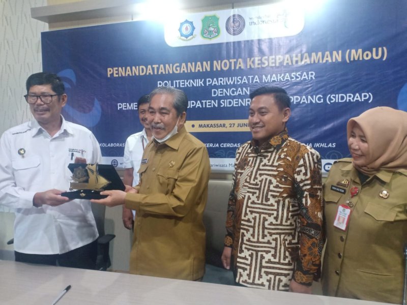 Direktur Poltekpar Makassar, Muhammad Arifin menyerahkan cendramata kepada Bupati Sidrap Dollah Mando, di Kampus Poltekpar, Senin (27/6/2022).