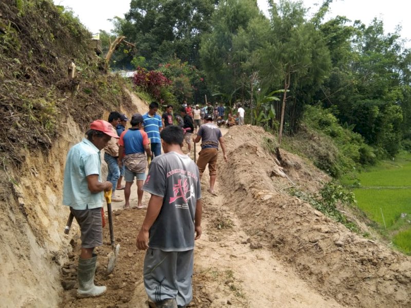 Warga bergotong royong mengevakuasi material longsor di Rantelimbong.