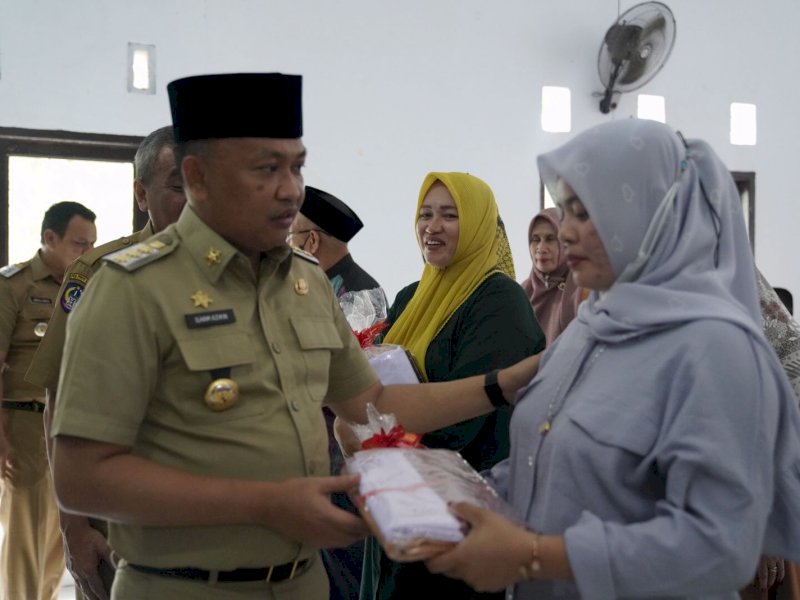 Bupati Bantaeng Ilham Syah Azikin menyerahkan kain perlengkapan sekolah gratis kapada kelompok penjahit Kecamatan Pa'jukukang, di Aula Kantor Kecamatan Pa'jukukang, Selasa (26/7).