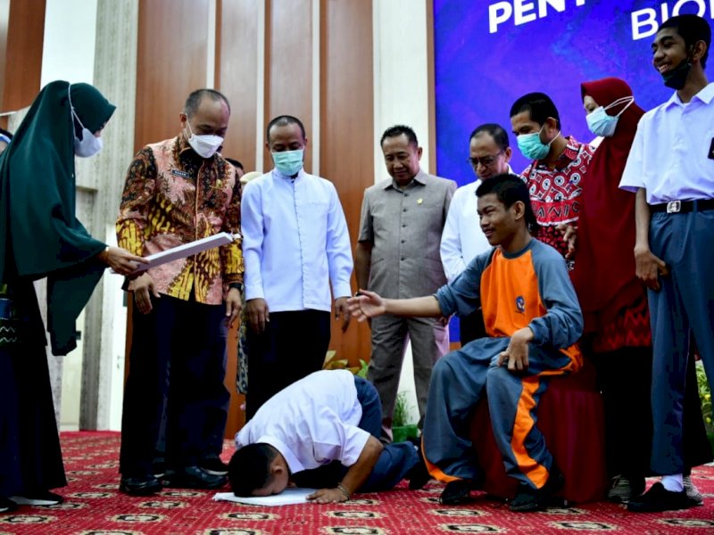 Momen saat seorang pria penyandang disabilitas sujud syukur usai menerima e KTP. 